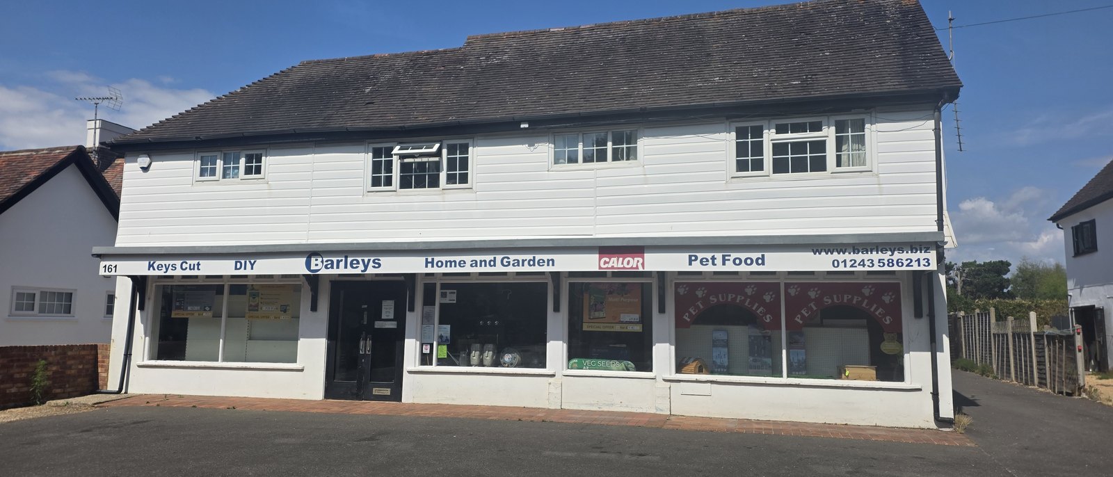 Barleys, a white weatherboarded shop with a long fascia reading keys cut, DIY, home and garden, Calor, pet food, and a window display of pet supplies