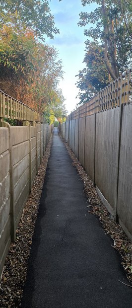The long twitten between Sea Way and West Close, a narrow path between a fence and shrubs